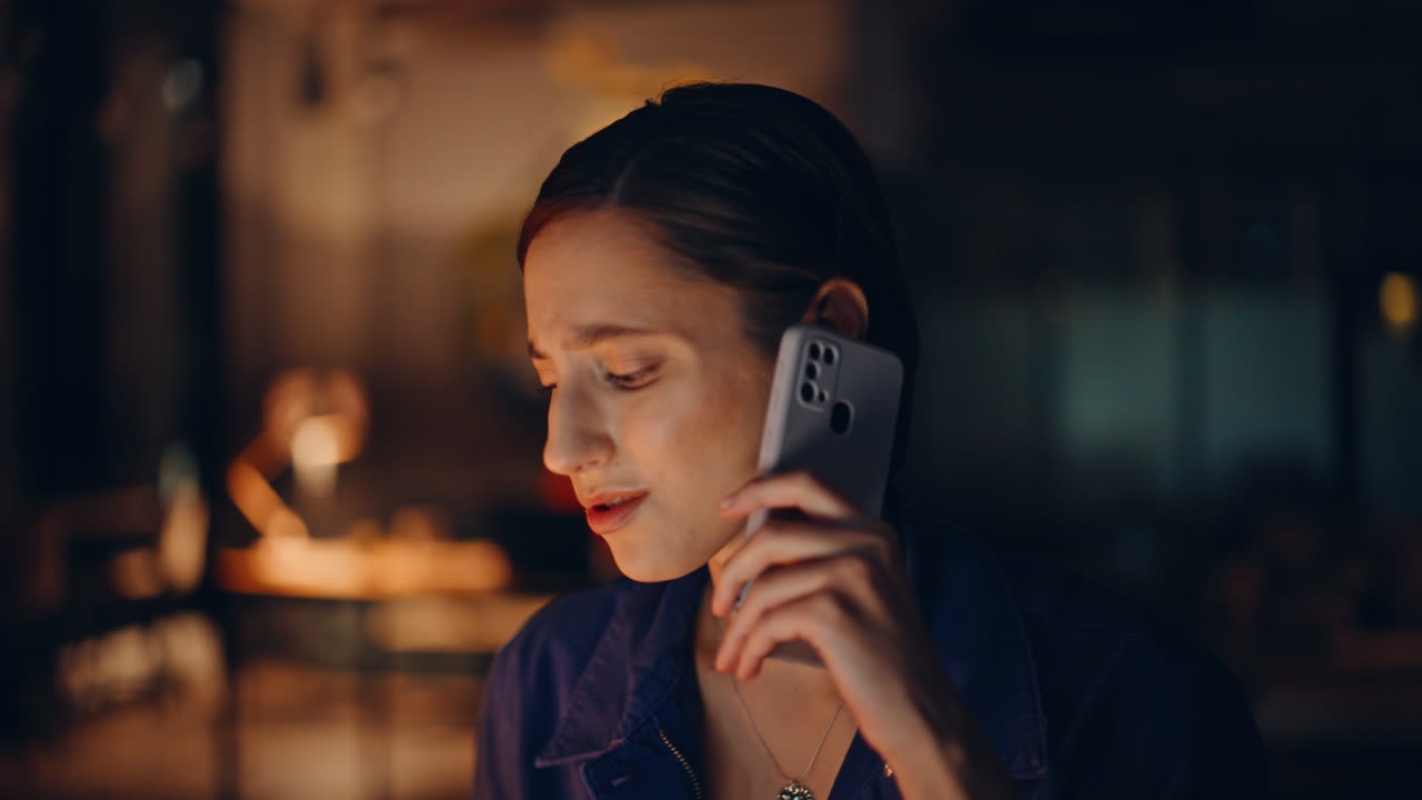 Stressed employee speaking smartphone at night coworking closeup. Worried woman