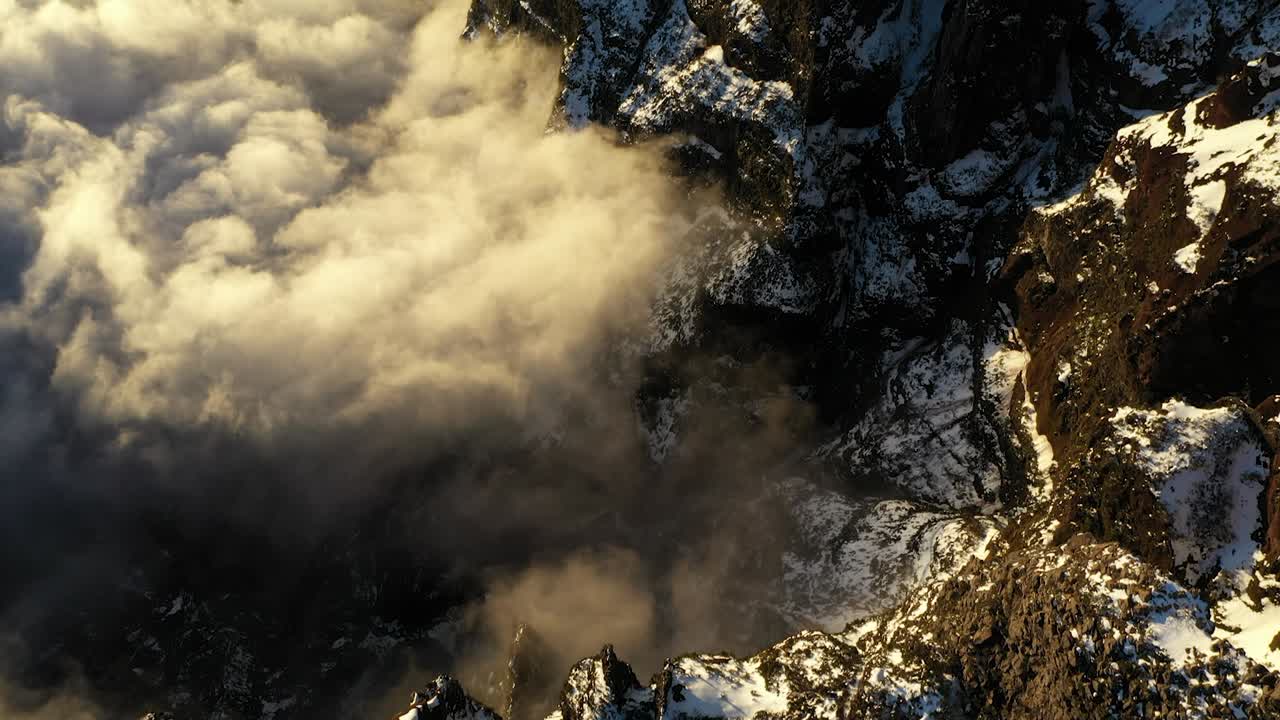 Drone shot of the valleys and peaks with clouds at the mountain Pico Ruivo in Madeira