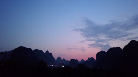 footage of a beautiful sunset over the green, lush and dense karst mountain landscape in yangshuo, guangxi province, china