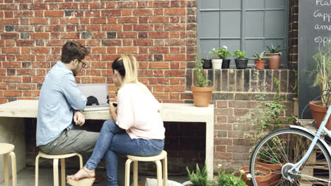 young couple dating using computer in cafe