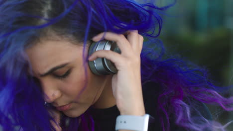 mujer joven de moda poniendo auriculares para escuchar