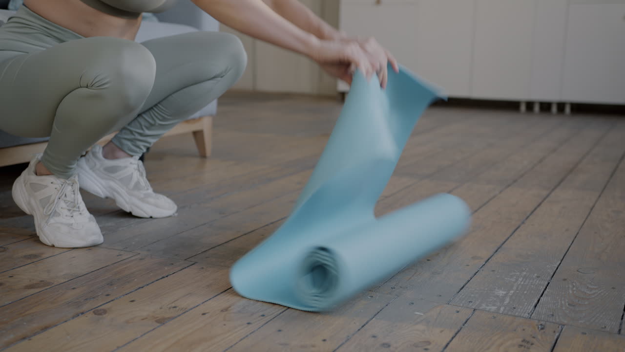 Woman Folding Yoga Mat at Home