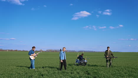 young musical band giving a concert on field. friends perform music with musical instruments under blue sky. outdoor entertainment.