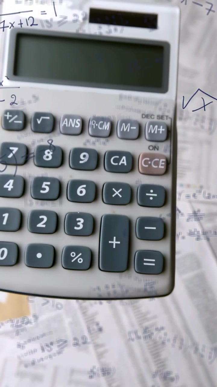 Video verticale: Telecamera che si allontana da un tastierino, rivelando una calcolatrice grigia e appunti di algebra.