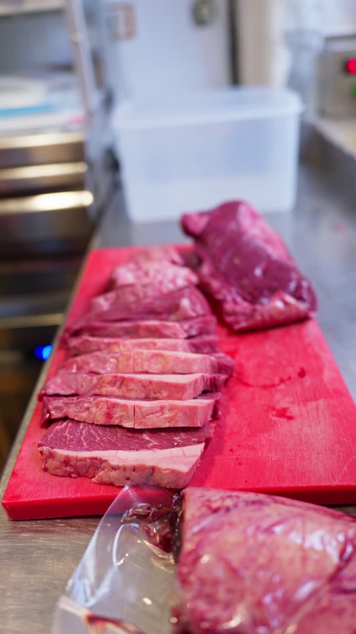 Chef Unpackaging Raw Beef from Vacuum Seal in Commercial Kitchen