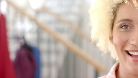 Close-up-of-a-smiling-young-biracial-woman-with-curly-blonde-hair-at-home-with-copy-space