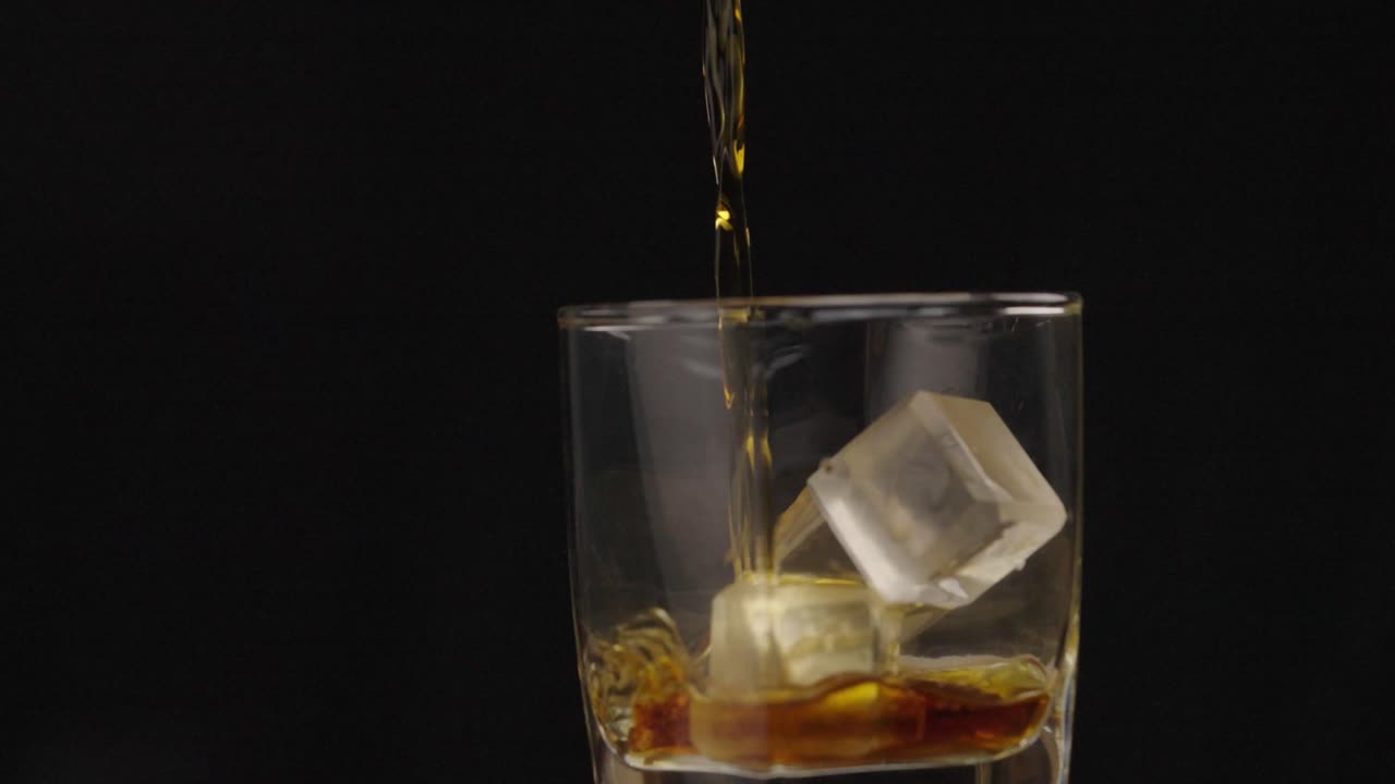 el alcohol se vierte en un vaso con cubitos de hielo