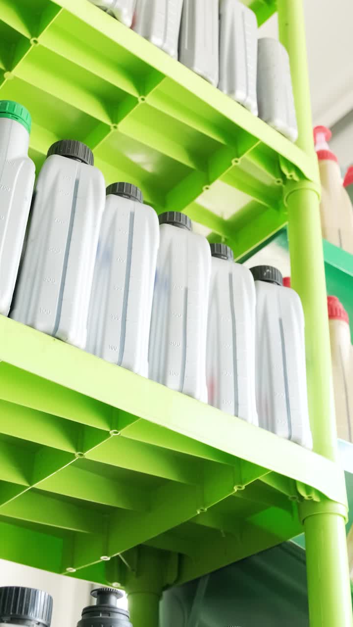 Reihen von Plastikflaschen auf hellgrünen Regalen