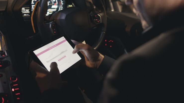 Uomo che verifica dati finanziari in un'auto di lusso