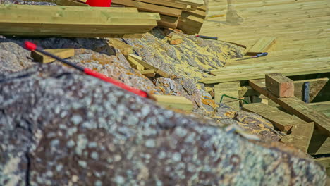 toma estática de un trabajador que construye un muelle de madera en una costa rocosa en un lapso de tiempo