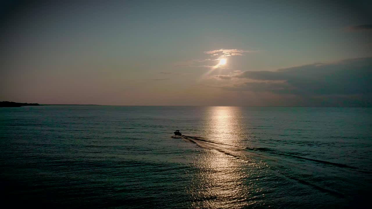 아름다운 일몰 동안 호수를 가로지르는 보트의 항공 영상