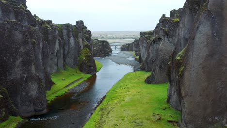 river flowing through beautiful fjaðrárgljúfur canyon, near kirkjubaejarklaustur, iceland - aerial drone shot