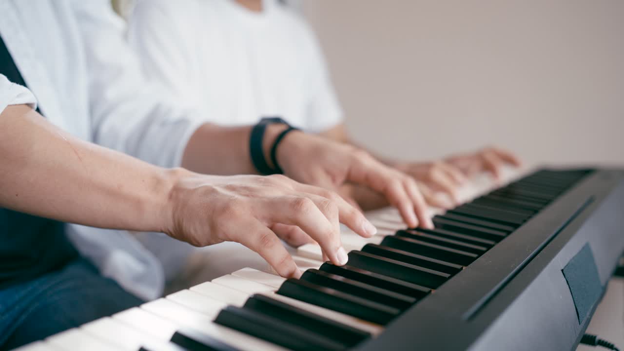Hands playing a piano keyboard