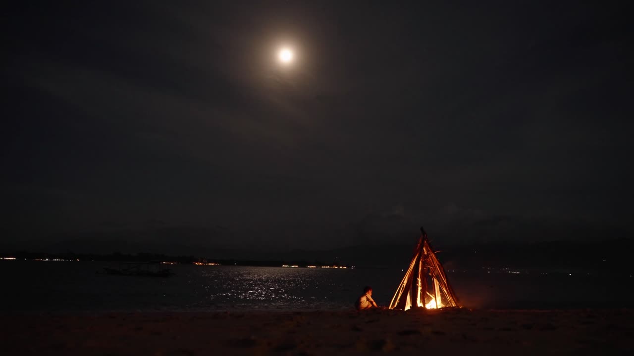 feu de joie brûlant sous la pleine lune tropicale au clair de lune sur la plage de komodo, indonésie