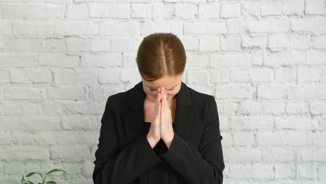 a woman praying with hands held flat together