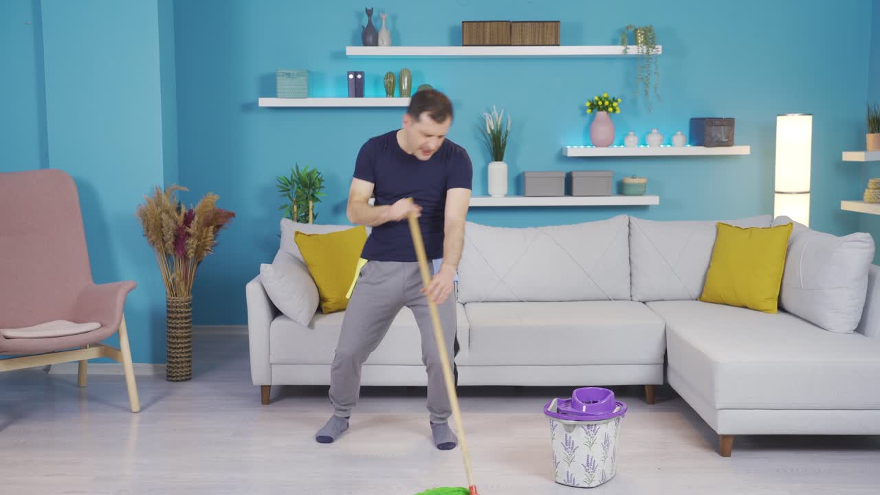 mientras limpia, el hombre que piensa que es un cantante comienza a cantar y hacer movimientos divertidos.