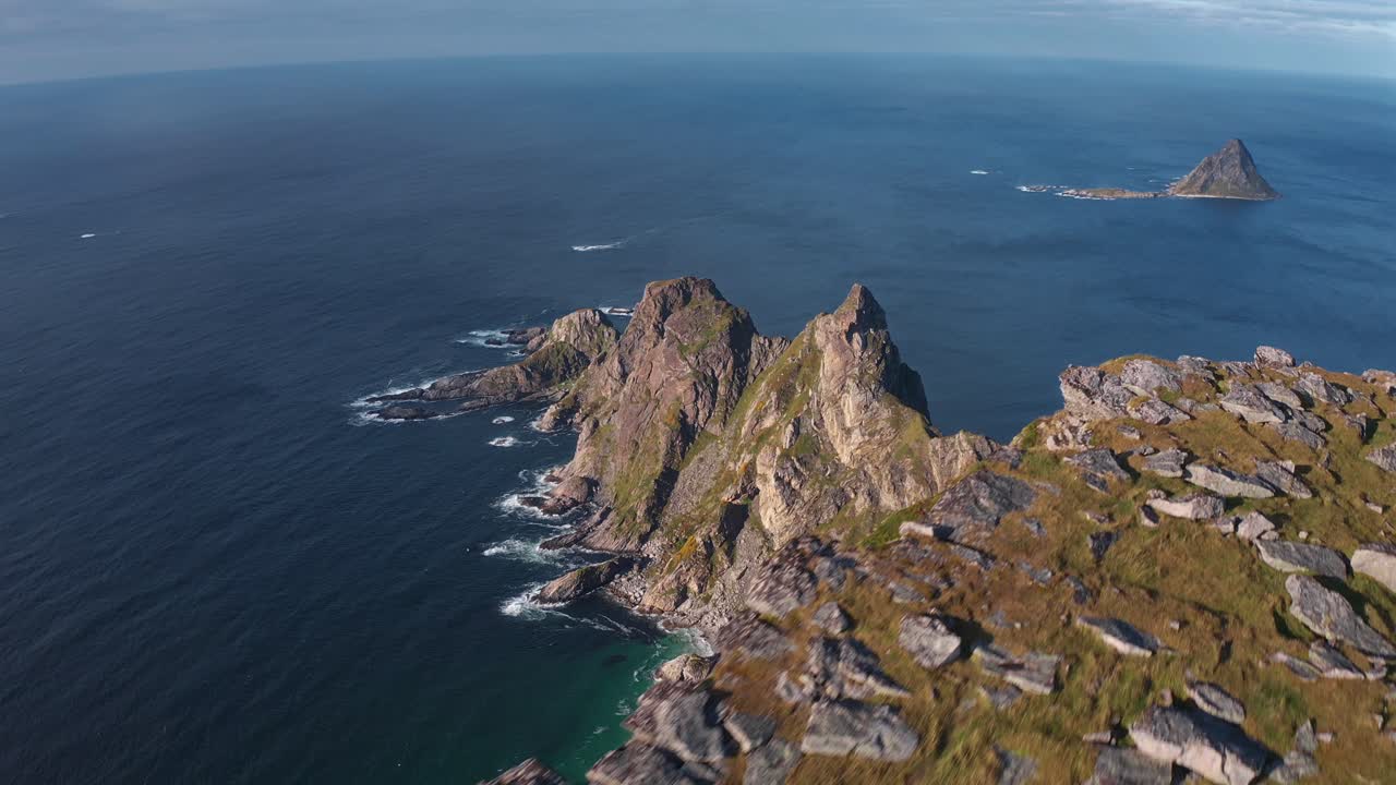 Stunning aerial shot of Måtinden with two tourists and a dog by the sea