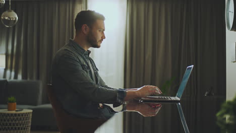 hombre trabajando en una computadora portátil en casa