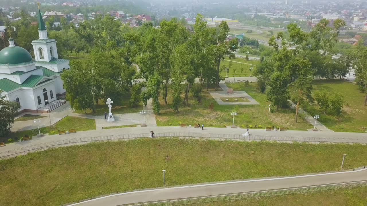 свадьба поцелуев рядом с церковью в парке воздушный вид