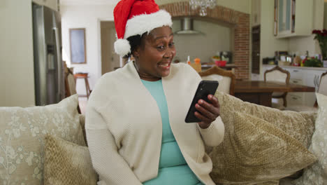 happy senior african american woman wearing santa hat at chrsitmas time