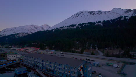 Drohne-Steigt-Auf,-Blick-Auf-Das-Harbour-360-Hotel-Und-Die-Berge-Bei-Sonnenuntergang-In-Seward,-Alaska