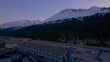 drone rising up view of harbor 360 hotel and mountains at sunset in seward alaska