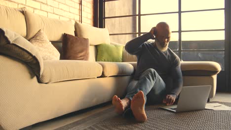 senior man using laptop in living room 4k