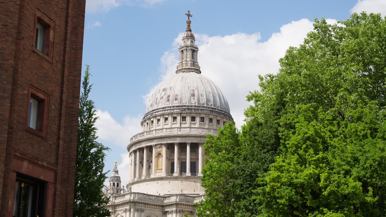 The Dome of St. Paul's Cathedral rising above the trees with a clear blue sky in the background in London, England