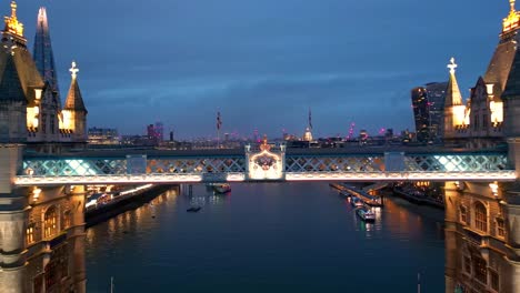 Dolly-Out-Drohnenaufnahme-Der-Tower-Bridge-In-London-Bei-Nacht,-Die-Lichter-Sind-An