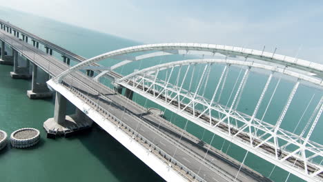 aerial view of a modern arch bridge over a sea