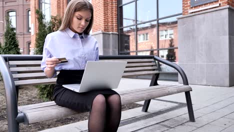 online shopping on tablet by woman sitting outside office