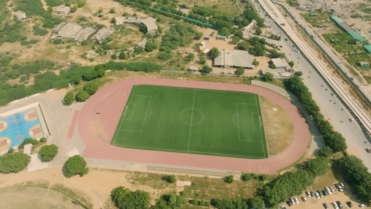 Aerial view of NED University of Engineering and Technology Karachi campus featuring the football field and running track on a sunny day in Pakistan