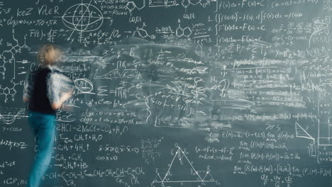student studying on a chalkboard covered with equations