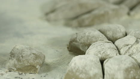 rolling bread dough on the flour at the bakery kitchen - slow motion