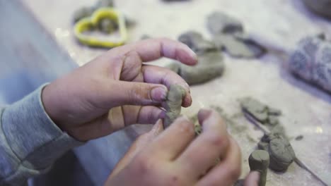 child hands working with clay