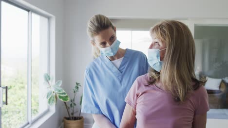 Trabajadora-De-La-Salud-Que-Ayuda-A-Una-Mujer-Mayor-A-Hacer-Ejercicio-Con-Pesas-En-Casa