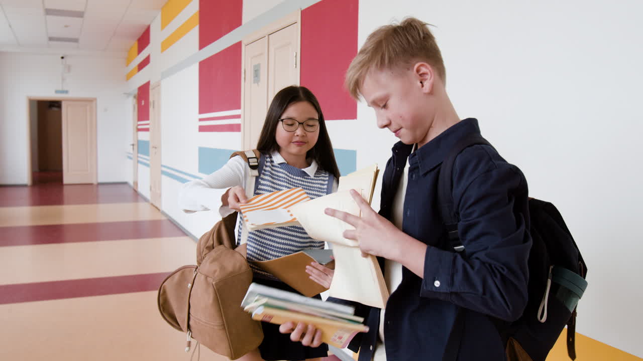 Students exchanging books in a school hallway
