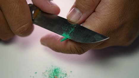 Footage-of-hands-slowly-sharpening-a-pencil-and-some-coloured-pencils-with-a-sharp-knife