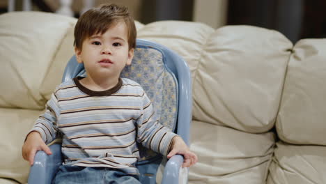 a hungry baby sits in a high chair. emotionally begging and waiting for your food