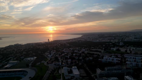una majestuosa vista del sol poniéndose sobre un océano tranquilo cerca de la ciudad costera de lisboa