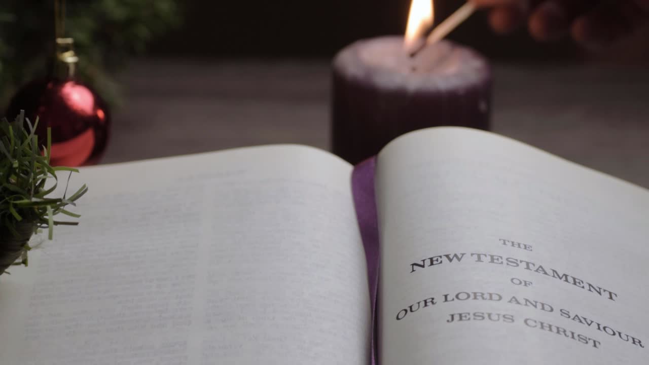 encendiendo velas en la lectura de la biblia en el fondo de navidad