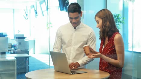 Business-colleagues-discussing-over-laptop