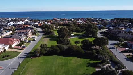 parque de sobrevuelo aéreo con el océano y la marina en el fondo, mindarie perth - australia