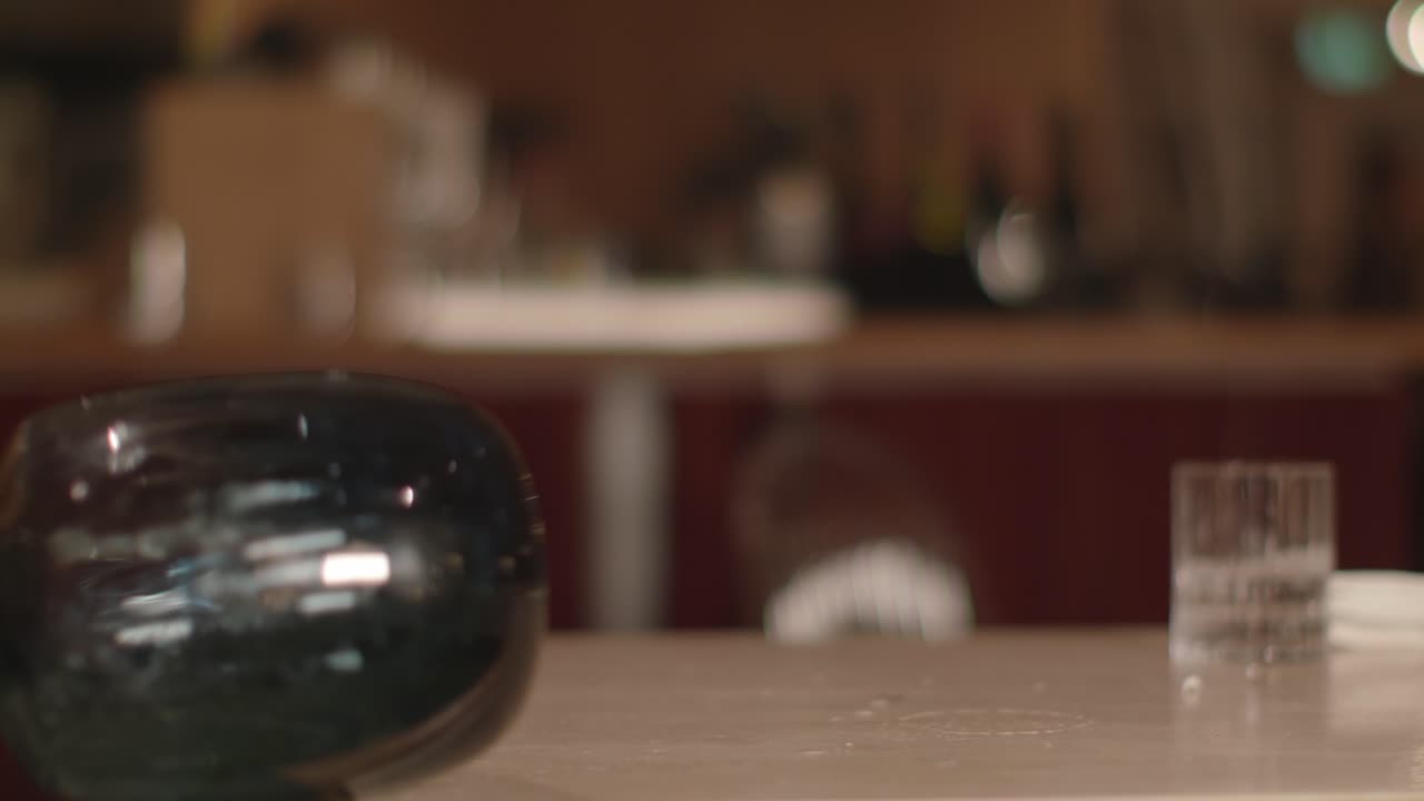 jarrón de vidrio con flores en la mesa de madera, cayendo repentinamente a un lado en el suelo