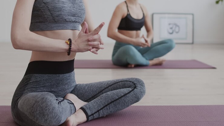 due donne irriconoscibili che meditano all'interno