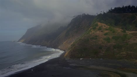usal beach campground pacific ocean waves camp tent trucks black sand california foggy daytime blue sky mist fog bluffs rugged lost coast remote untouched sinkyole wilderness nature landscape pan left
