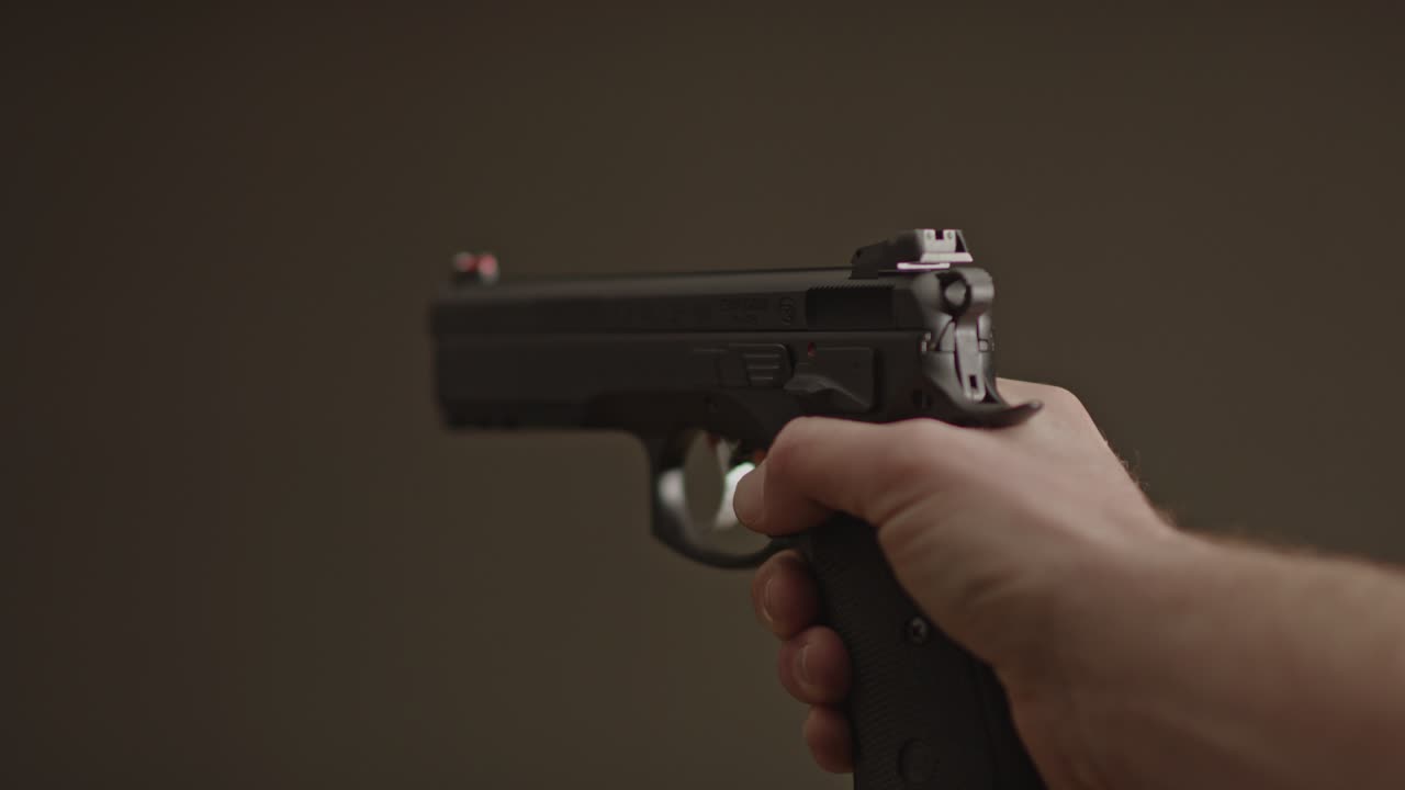 Single hand gently lowering 9mm handgun