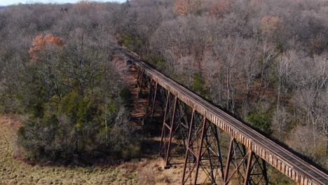 tight aerial shot of train tracks running off the pope lick trestle and into the woods in louisville kentucky