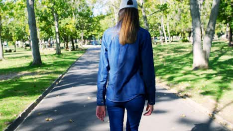 woman walking on pathway in the park 4k