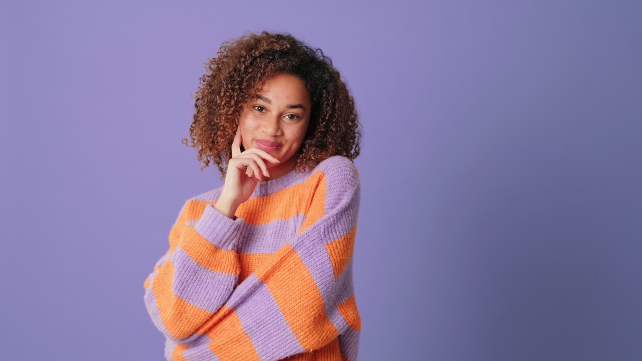Shy Young Woman with Curly Hair Smiling and Pondering